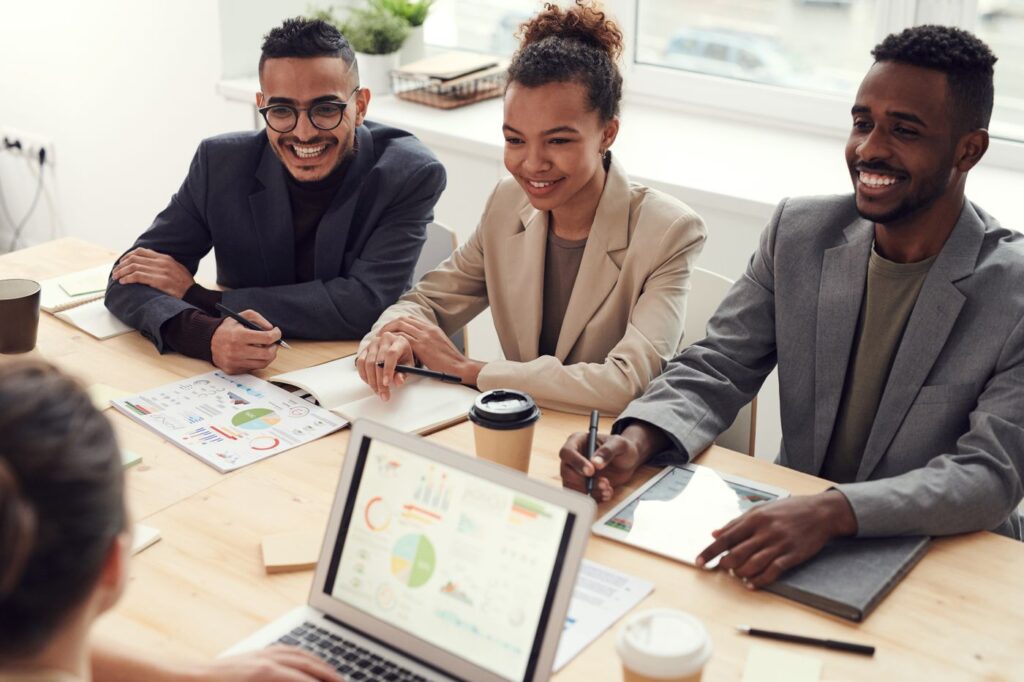 Small business team meeting around a table with laptops