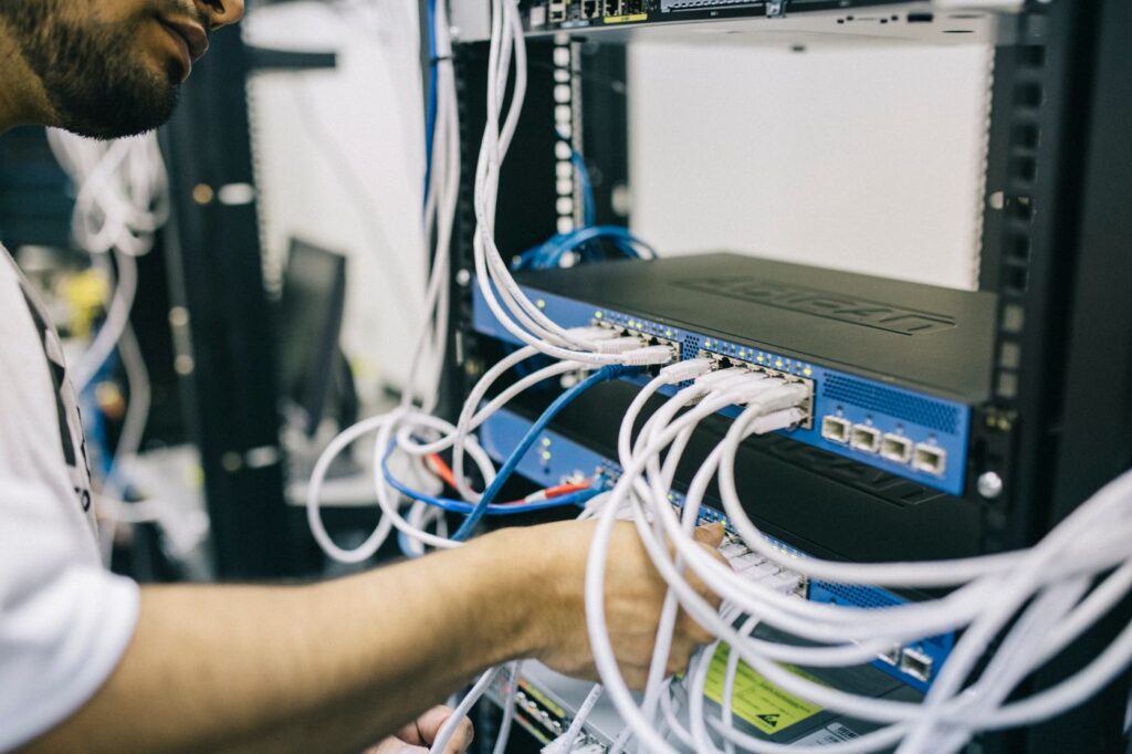 Technician working on network cabling in a server rack